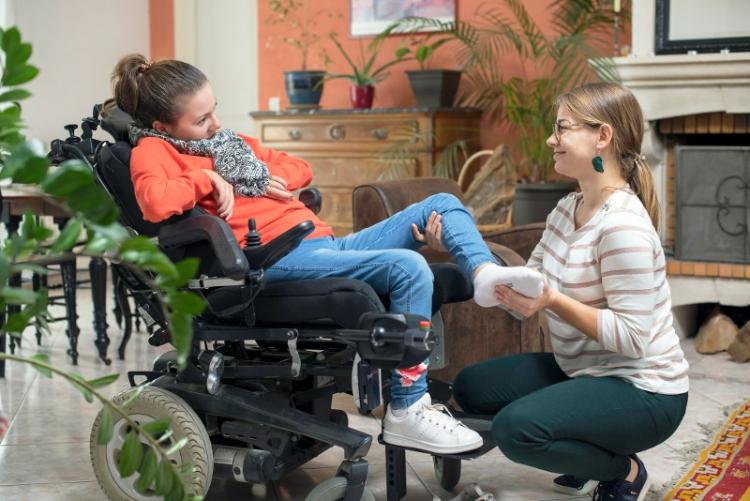 femme en fauteuil roulant avec intervenante